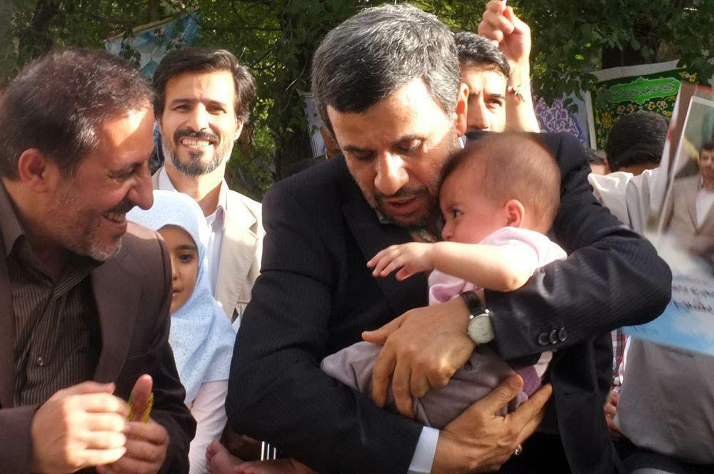یک بچه قنداقه در بغل محمود احمدی‌نژاد +عکس