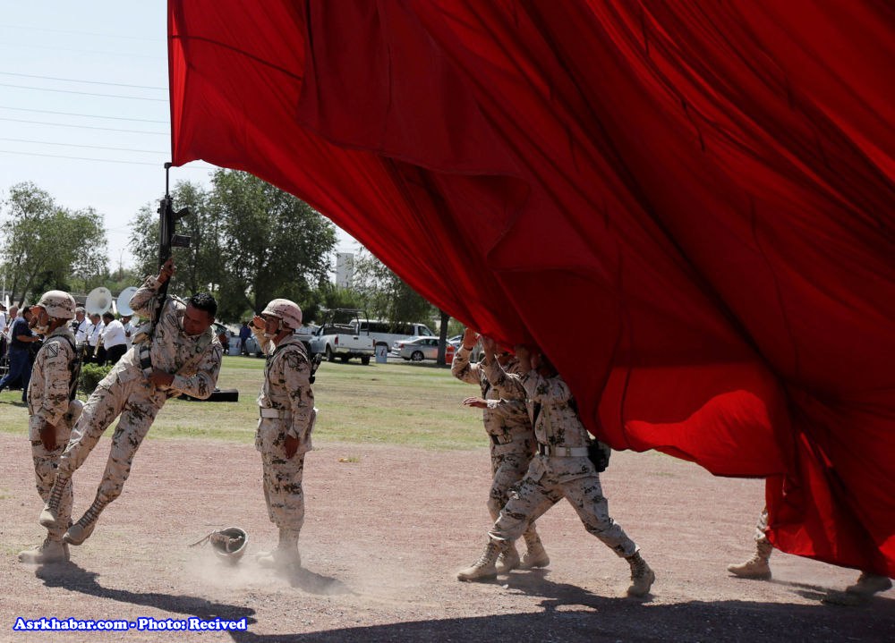 سرباز مکزیکی در حال نگهداشتن پرچم غول پیکر + عکس