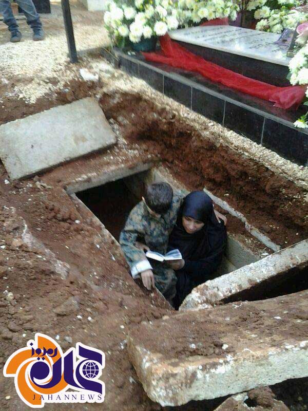 قرآن خواندن همسر شهید در قبر شوهرش+عکس